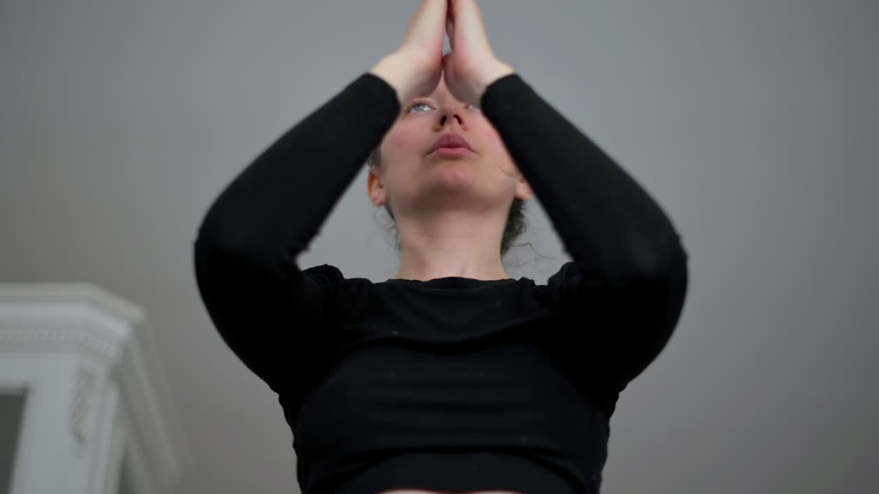 스포츠 의류 를 입은 여자 가 집 에서 요가 를 하고 있다