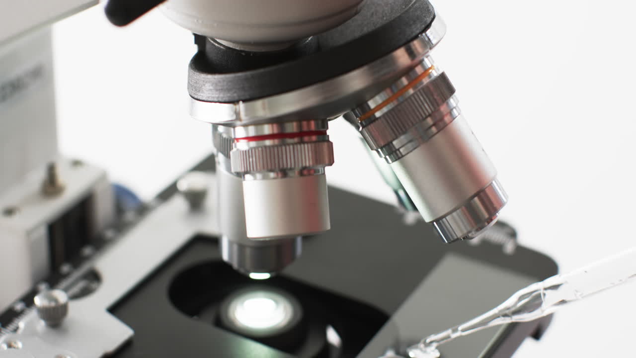 백색 배경에 복사 공간과 함께 실험실 현미경의 클로즈업 비디오