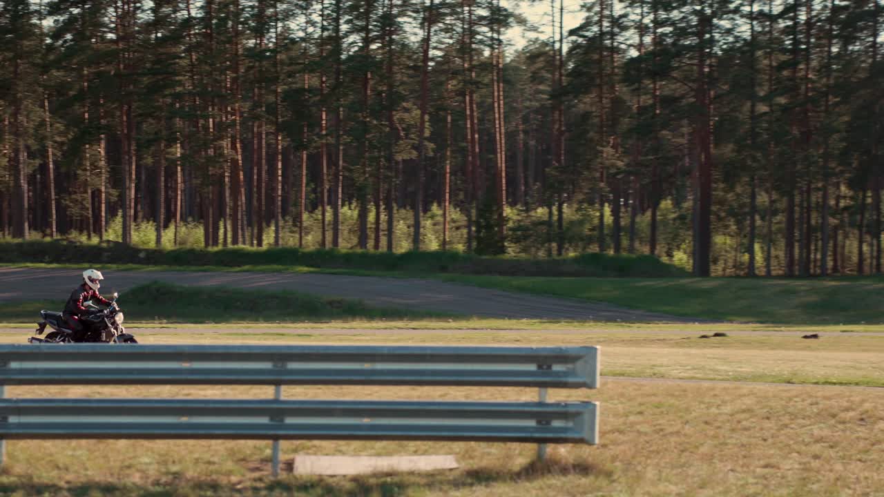 motociclista en motocicleta está practicando para la carrera en la carretera de asfalto en el bosque