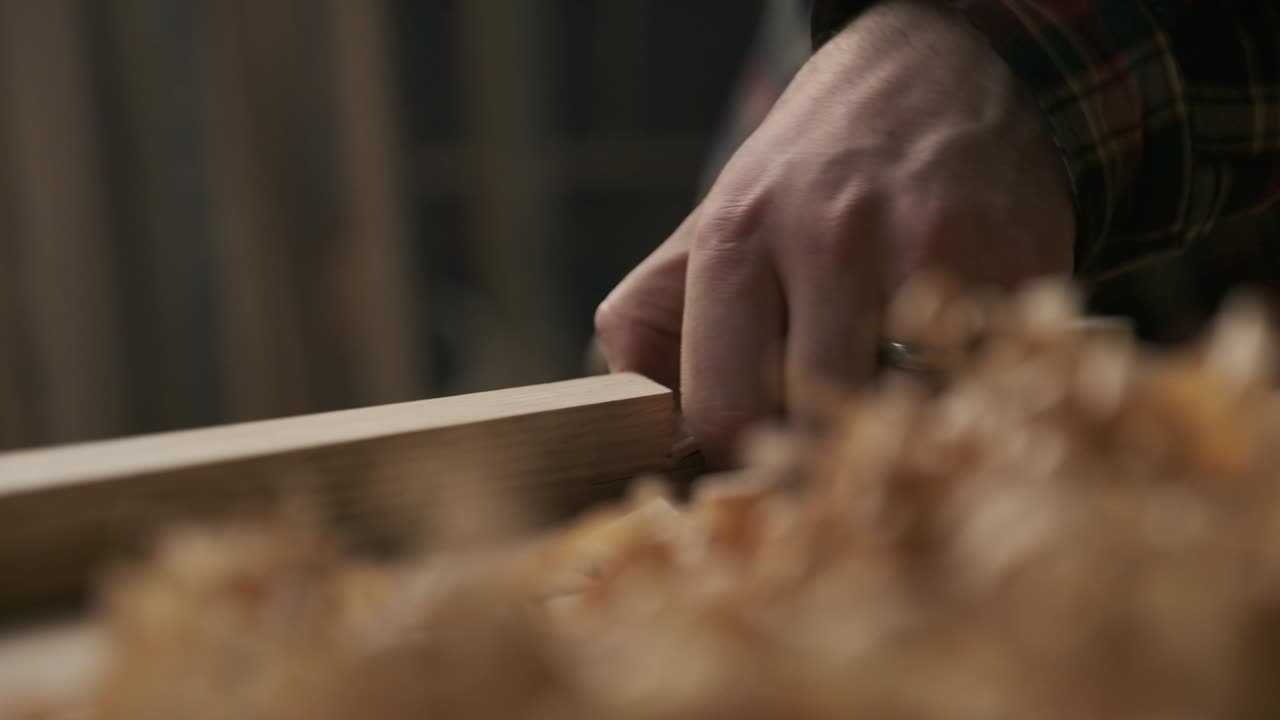 Carpenter working with pouch in moody workshop