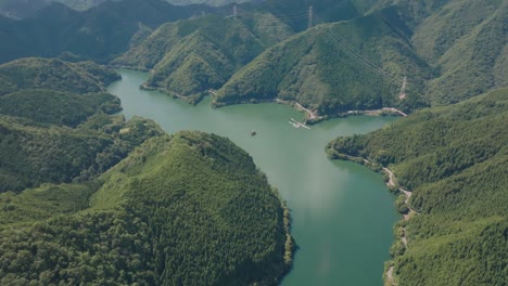 Paisaje-Aéreo-Del-Lago-De-Agua-Turquesa-Entre-El-Bosque-De-Cedros-En-Kyoto,-Japón,-Kansai,-Entorno-Natural-Que-Establece-Una-Vista-Panorámica-De-Drones