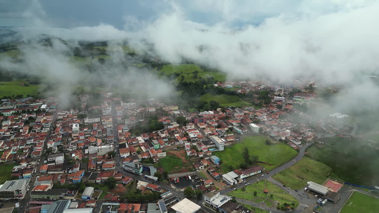 aerial dolly reverse view of Bueno Brandao town covered by foggy during a cold winter day - Small city in the countryside of Minas Gerais - Brazil