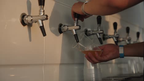 bartender pouring beer from tap, at a festival