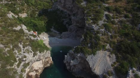 secluded beach hidden by jagged steep rock walls with narrow passage to the sea