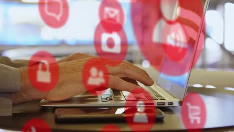 animación de múltiples iconos sobre manos recortadas de un hombre caucásico trabajando en una computadora portátil en la oficina
