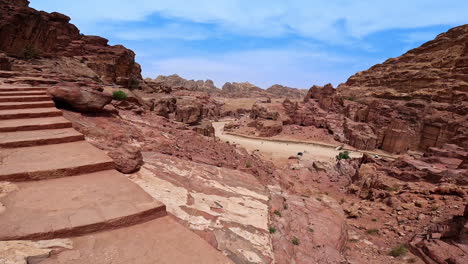 going up by the stone stairs cut in the bare rocks. spectacular scenery of petra, jordan, west asia from top of the rock.