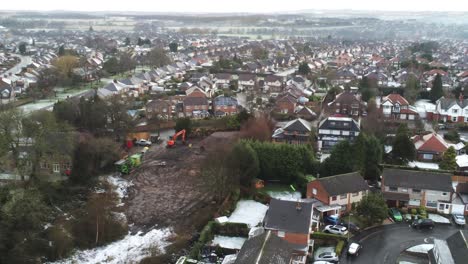 snowy aerial village residential neighbourhood winter frozen north west houses and roads descending across building site