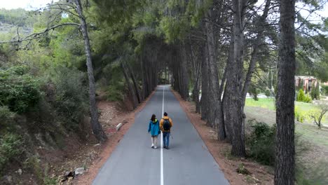 couple hiking through a pine tree tunnel