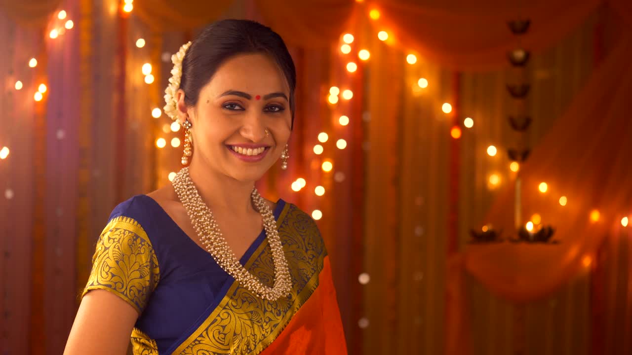 Indian beautiful woman dressed in ethnic wear smiling looking into the camera - Greeting