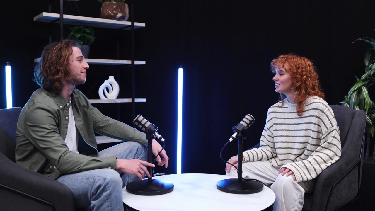 Młody mężczyzna i kobieta nagrywający podcast w nowoczesnym studiu