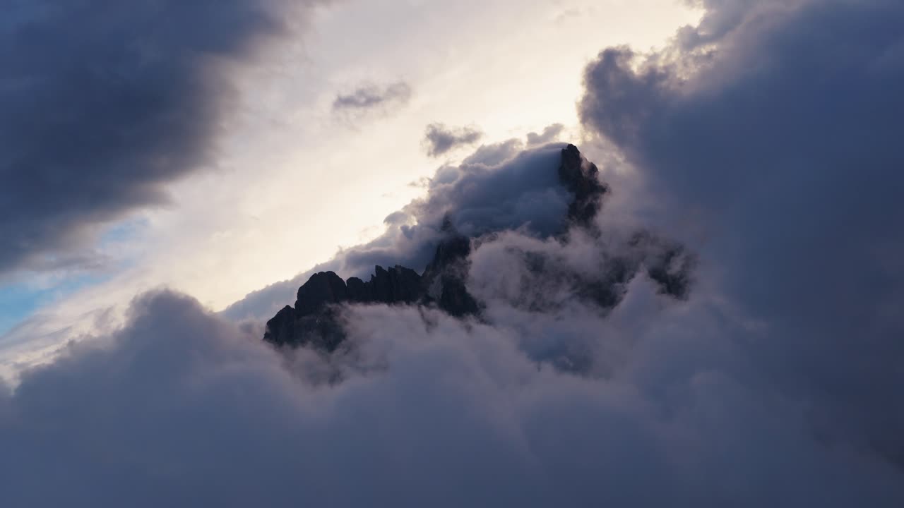 Misty Dolomites peak surrounded by clouds in looping shot, serene view