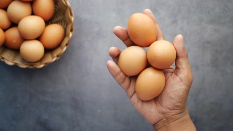 Hand-pick-eggs-from-a-plastic-case-on-table-,