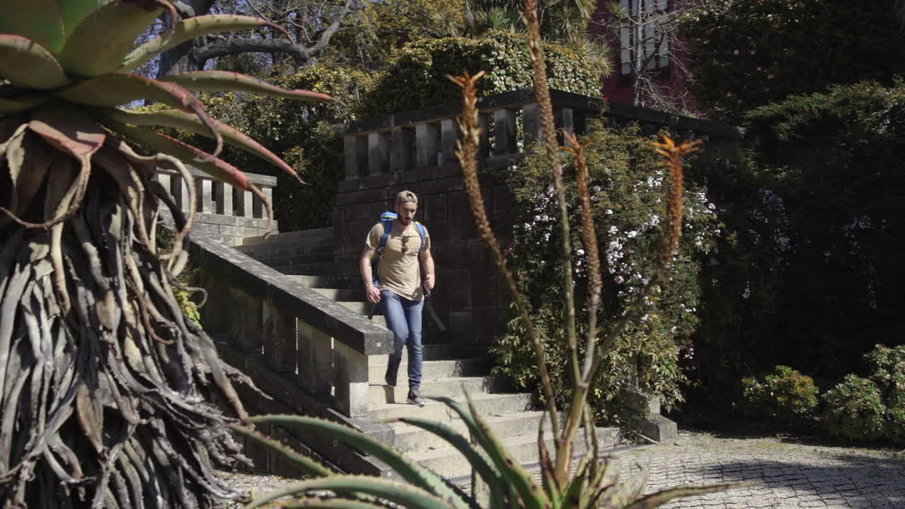 Mochileros bajando por una escénica escalera exterior hacia un jardín botánico natural y verde en la ciudad de Oporto, Portugal