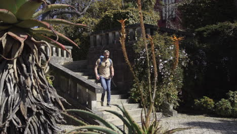 backpackers walking downstair outdoor in scenic stairway down to natural green botanic garden in the city in porto portugal