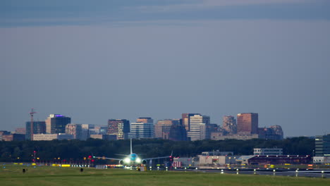 airplane taking off or landing at night with city skyline in background