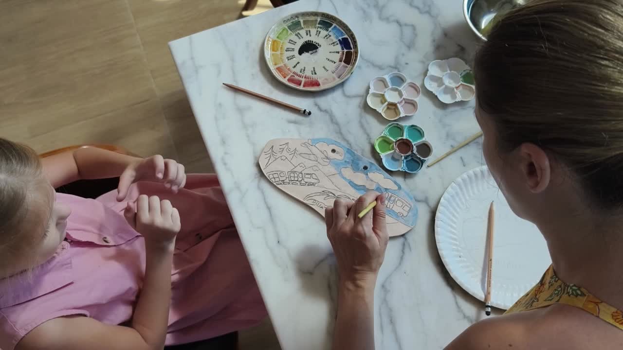 madre e hija pintando cerámica