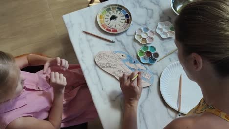 mother and daughter painting pottery