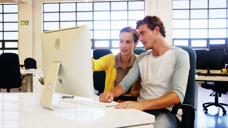 Colleagues looking at computer and discussing with each other