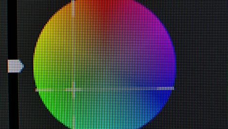 color correction circle wheel on the monitor screen close up. pixels zoomed in with red, blue, and green glowing crystals and patterns on a computer graphics monitor