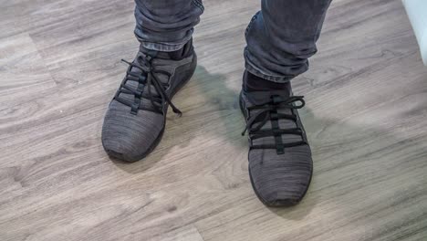 person wearing grey and black shoes checks if footwear is right for him