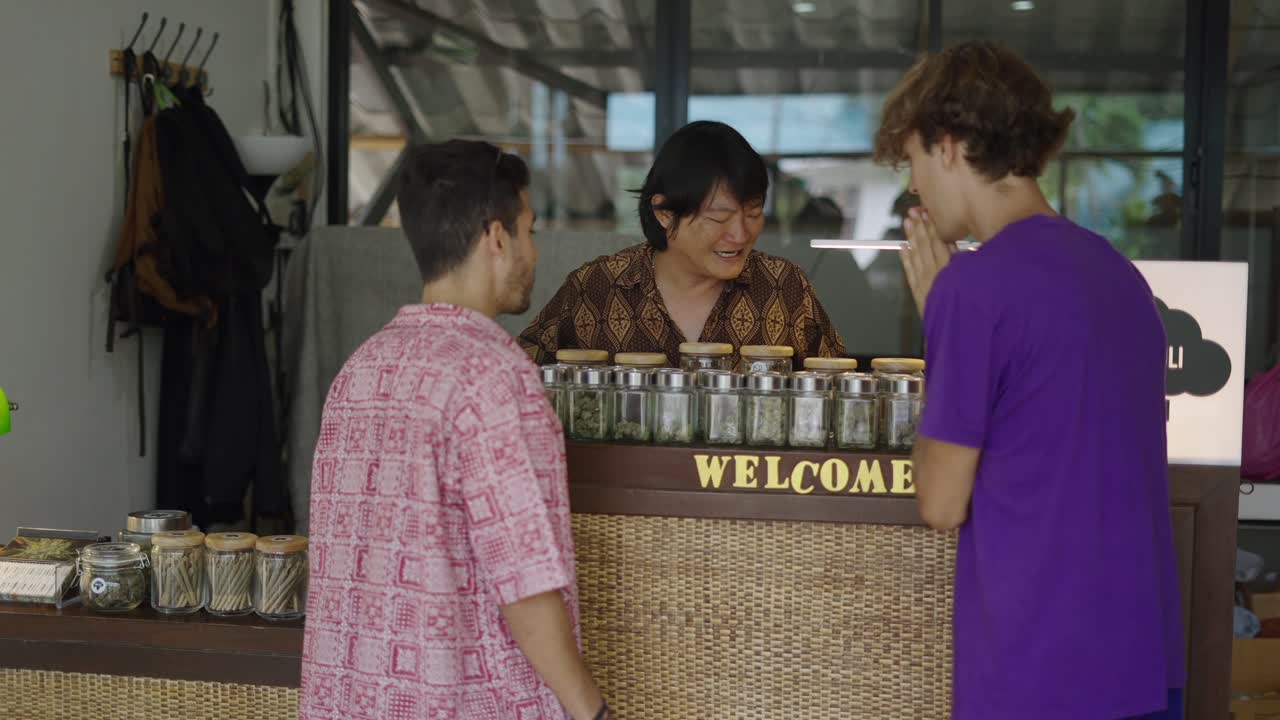 Customers interacting with a shop owner at a cannabis dispensary