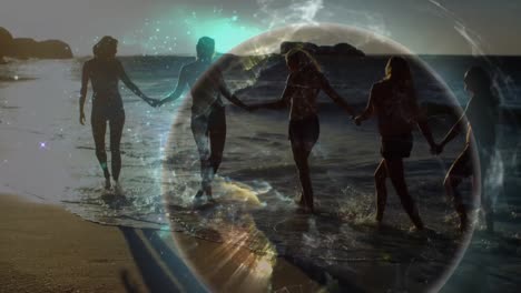 animation of glowing global network over female friends in bikinis holding hands walking on beach