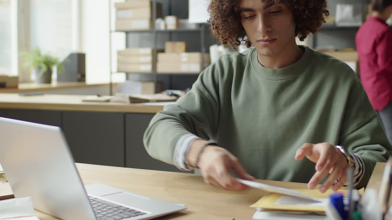 Man working at desk with laptop and mail