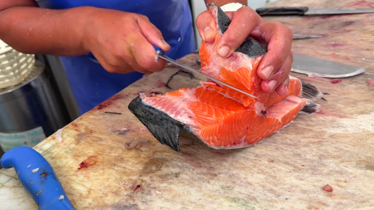 Close-up of a Person Filleting Fresh Salmon on a Cutting Board