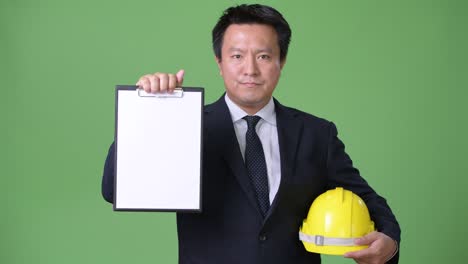 녹색 배경에 성숙한 일본 사업가