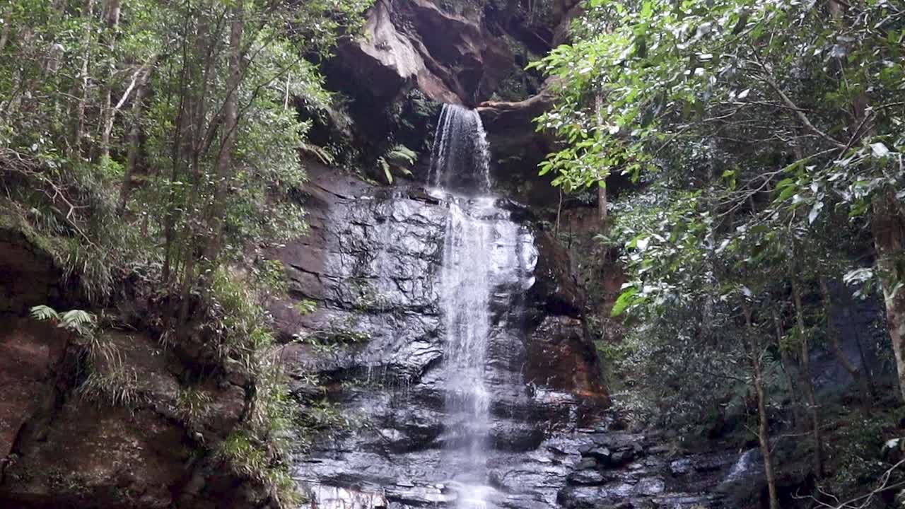 Pan down shot of water cascading over Wentworth Falls, Australia