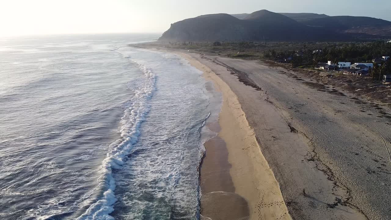 Spiaggia messicana della Bassa California del Sud con onde che si infrangono sulla costa dell'Oceano Pacifico durante il tramonto.