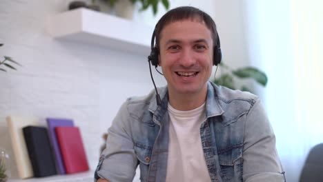 Head-shot-millennial-guy-sit-in-living-room-makes-video-call-looks-at-camera,-conversation-by-distant-videocall,-distance-hiring-job-interview-process,-tutor-and-trainee-study-on-line