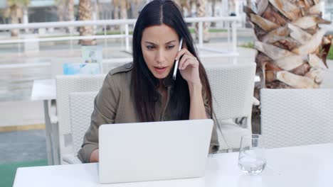 Young-businesswoman-working-at-an-outdoor-cafe