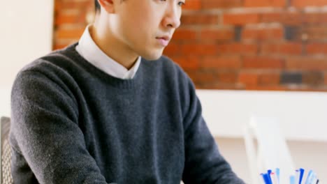 Male-executive-using-laptop-at-desk