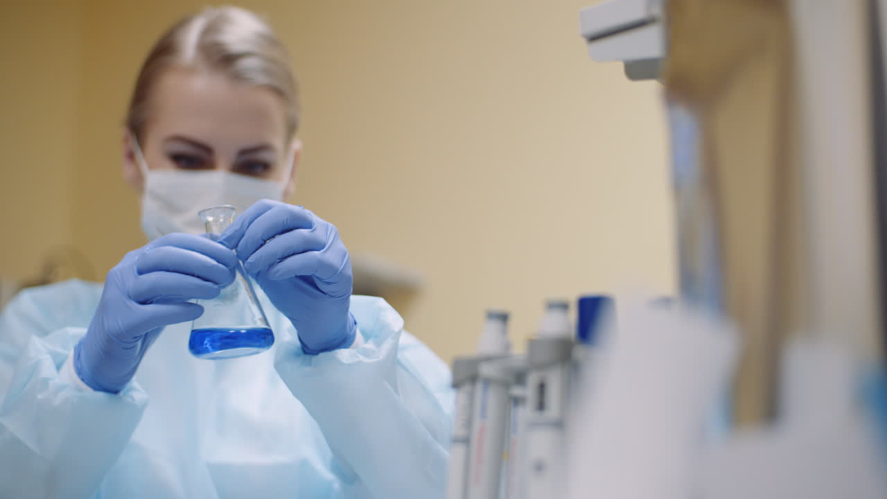 ученый перемешивает жидкость в лаборатории 4