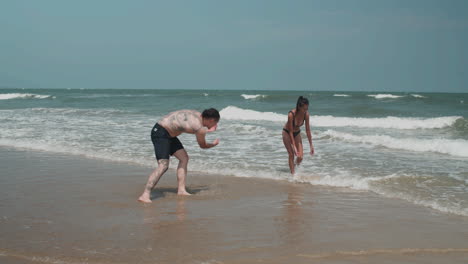 pareja jugando en la orilla