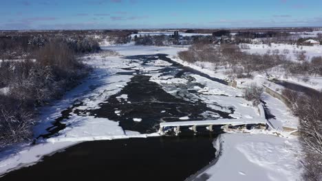 Río-De-Invierno-Con-Viejo-Puente-Roto-Y-Enfoque-De-Nieve-Fresca