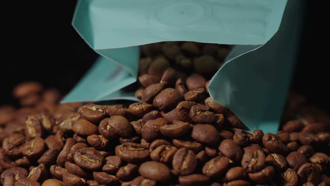 Cena estática com foco sendo alterado de grãos de café para um saco de café.
