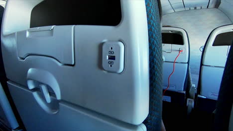 imágenes de un viajero conectándose a un puerto usb en un avión