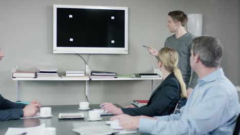 young men gives a presentation in a meetingroom for his colleagues