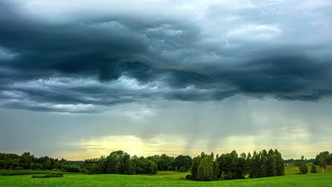 sunset rains over a countryside meadow and forest - time lapse