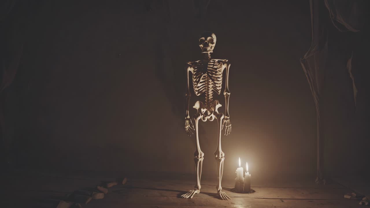 A dimly lit video scene with a skeleton standing near a candle