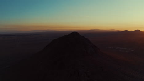 órbita-Aérea-De-Un-Pico-De-Montaña-En-Forma-De-Cono-Volcánico-Inactivo-En-El-Desierto-De-Mojave-Al-Amanecer