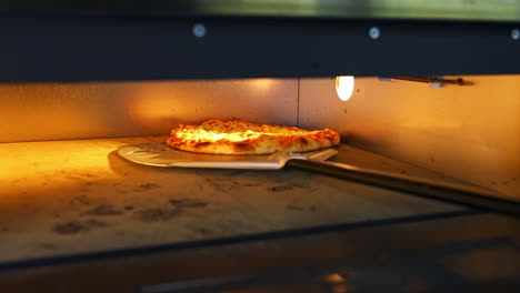 pizza in oven. baking pizza. the chef is turning hot pizza with a spatula in a stove. process of cooking pizza in pizzeria. tasty cookery.
