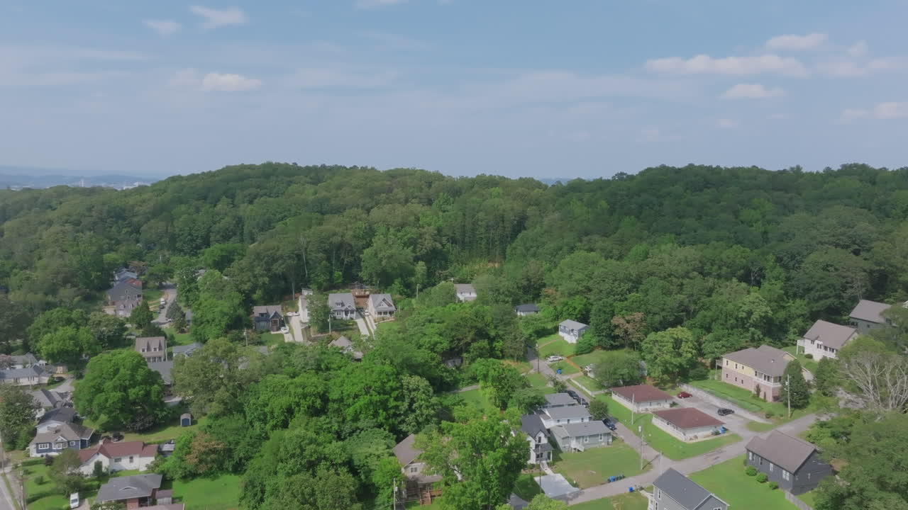 Drone footage of a heavily wooded hillside neighborhood in St. Elmo, Chattanooga, dotted with charming homes