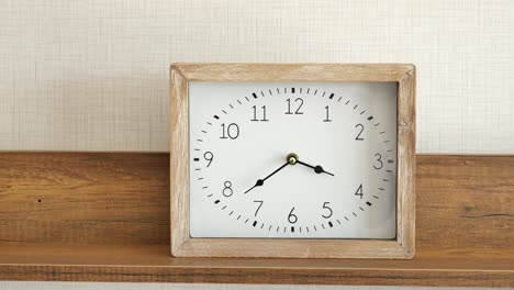 wooden frame wall clock on shelf