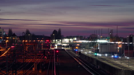 lapso de tiempo de los trenes de berlín que se mueven en las vías del tren al atardecer -estación de westhafen-vista estática elevada