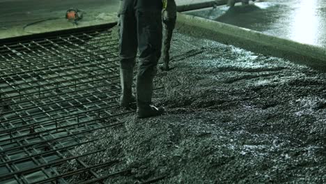 reinforced concrete. worker concretes foundation, rebar, pour cement mortar on reinforcing mesh. builders are building a factory, hangar.