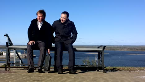 businessman with suitcase on bench like secret agent