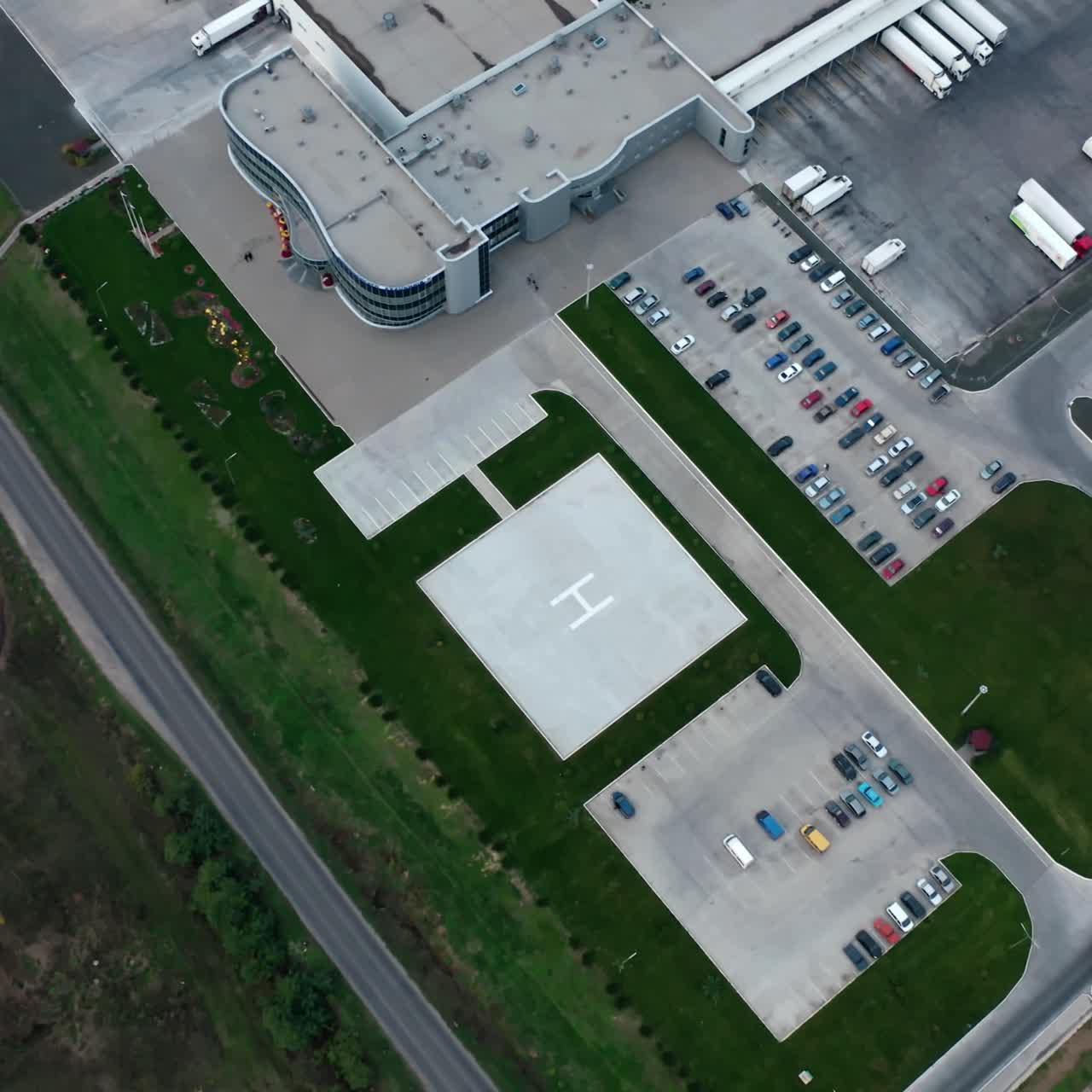 Industry near the road. Parking zone with cars and trucks on the industrial territory on field. Top aerial view.